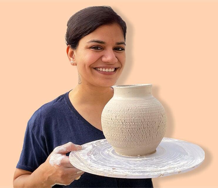 A profile picture of Sona Srivastava holding a leather hard vase of clay